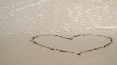 4k. mavi deniz yumuşak dalga ile kum plajda çizim kalp, beyaz kabarcık köpük ile dalgaokyanus dalga