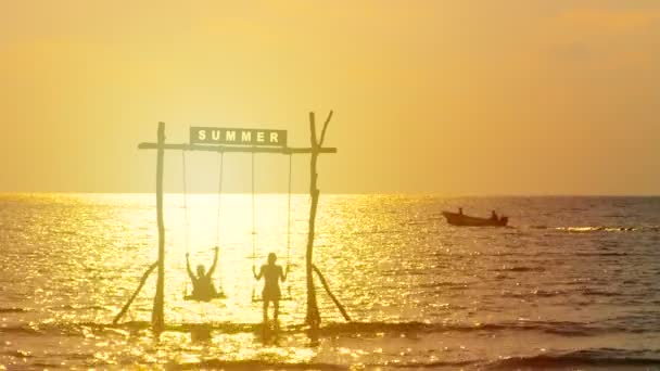 幸福夫妇的剪影享受在日落时间 夏天标志在日落期间在海面上摇摆 快乐暑假理念 — 图库视频影像
