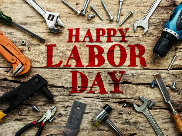 İnşaat onarım araçları ile ahşap arka plan üzerinde kırmızı renkli Happy Labor gün metin. — Stok fotoğraf