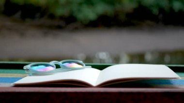 4k. pırıl pırıl nehir arka plan karşı ahşap masada saksı ile boş kitap sinemagrafı