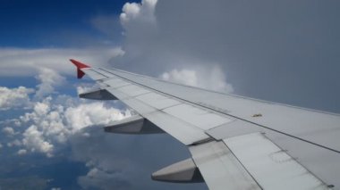 4k görüntüleri uçak iniş uçuş. beyaz bulutlar ve mavi gökyüzüne uçan bir uçağın kanat. uçakla seyahat süresi pencere düzleminden güzel havadan görünümü. tatil , tatil zamanı