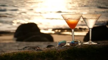 4k. gün batımı nda kalp bokeh ile altın dalga yansıması ile plajda su damlacıkları ile kokteyl cam
