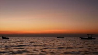 4k. gün batımı veya gündoğumu zaman küçük dalga ile deniz üzerinde küçük tekne silüeti, güzel güneş ışığı su yüzeyi ile yansıtır