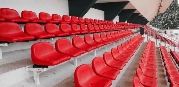 Vista lateral de la fila vacía de asientos de plástico rojo en el estadio de fútbol deportivo. asientos del estadio fondo — Foto de Stock