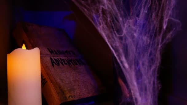 4K. halloween background concept. old haunted adventure book with candle light and spider web in the dark place decorate for halloween party with haunting effect