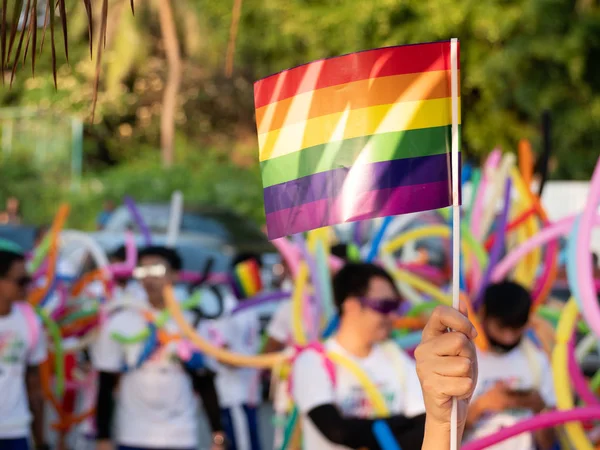 Lgbt stolzer Monat Hintergrund. Ein Zuschauer schwenkt eine schwule Regenbogenfahne beim lgbt Gay Pride Parade Festival in Thailand — Stockfoto