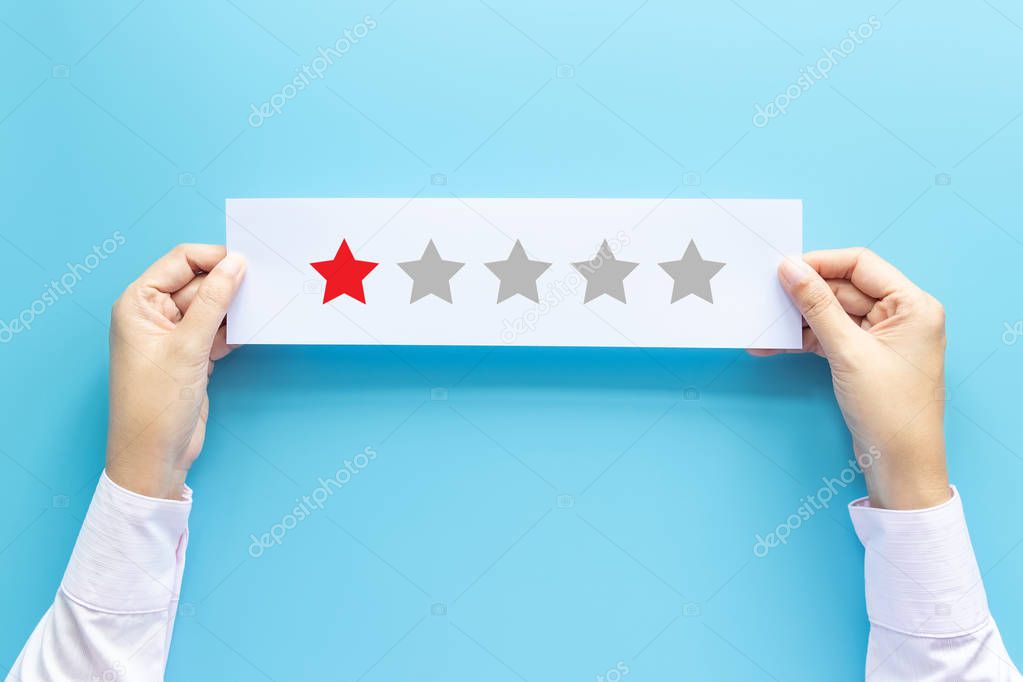 rating and feedback concept. customer holding paper with poor satisfied review by give one star for service experience