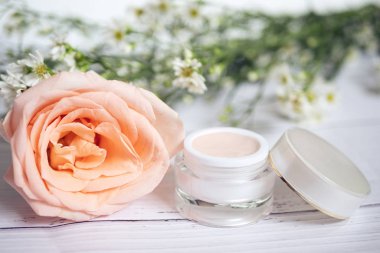 Cilt bakımı. Pembe cilt kreminin ürünü. İçinde büyük pembe gül ve arka planda küçük beyaz çiçek olan boş etiket var.