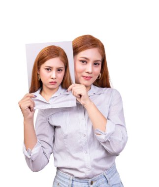 Bipolar bozukluk konsepti. Mutlu yüzlü yalnız genç Asyalı kadın 2 farklı duygu için mutsuz olduğunu göstermek için maske tutuyor.