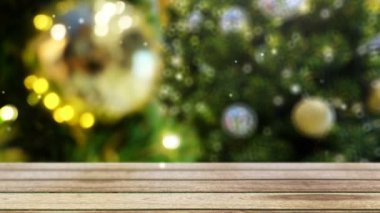 4 bin. Kar, bulanık noel ağacının önündeki ahşap masaya düşer süs topu ile süslenir ve arka planda fotokopi alanı ile ışıklandırılır.