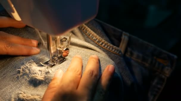 4K映像 ミシンで青いデニムジーンズを修理するための女性の縫製のクローズアップ — ストック動画