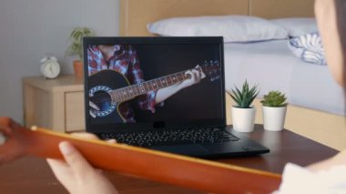 4 bin. Müzik akademisi online ders konsepti. Gençler boş zamanlarını evde ilginç aktiviteler yaparak internet sitesinden bilgisayar uygulaması üzerinden gitar akoru çalmayı öğrenerek geçiriyorlar..