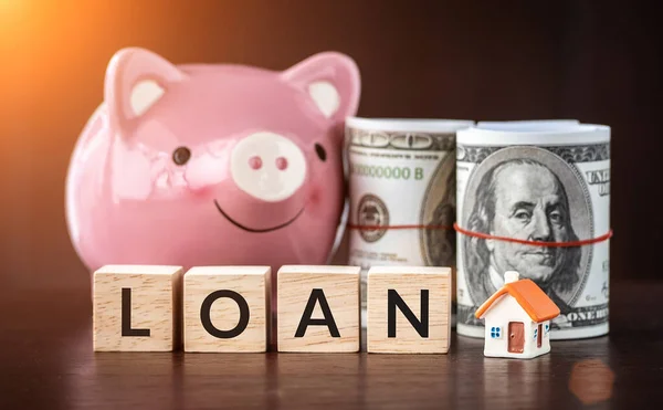 房地产销售 住房贷款市场的概念 带文字贷款木制立方体的模型房子 笑容可亲的粉红小猪银行和钞票 — 图库照片