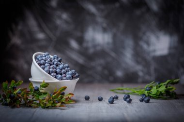 Tahta arka planda taze organik orman yaban mersinleri