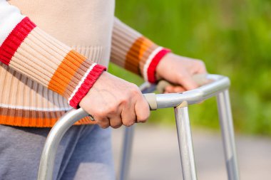 Yürüteç kullanan yaşlı bir kadın.