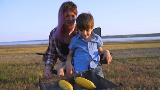 Madre Hijo Cocinan Maíz Una Parrilla Picnic Orilla Del Río — Vídeo de stock