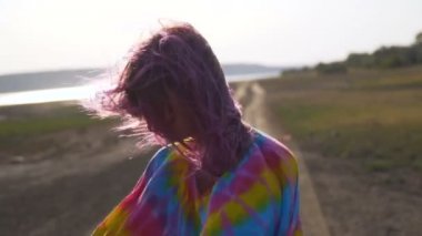 çok renkli bir elbise güzel kız gün batımında, hippi tarzı, altın saat, 100 fps yol altına gider