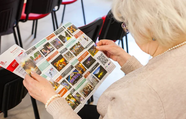 Kitapçığı olan genç bir kadın.