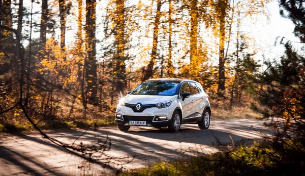 Dağlık alanda sonbaharda Otomobil beyaz Renault Captur, Ukrayna