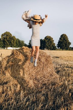 Küçük kız Outdoors doğa zevk. Samanlıktan atlama