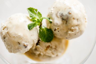 Fındıklı ve cam bardakta nane yapraklı kremalı dondurma. Yakın plan. Makro fotoğraf. Seçici Odaklanma.