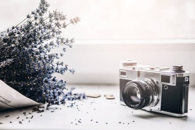 Beyaz arka planda bir demet lavanta ve ahşap kalpli klasik fotoğraf makinesi. seçici odak