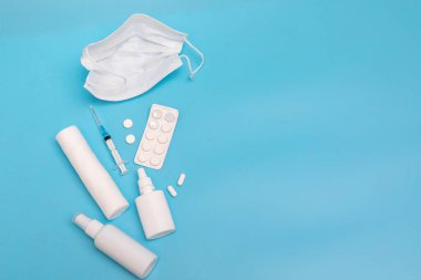 Burun spreyi, haplar, şırınga, mavi arka planda bandaj enjeksiyonu. Tıp konsepti. Model.