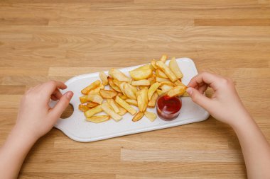 Beyaz dikdörtgen tabakta ketçaplı taze patates kızartması. Dilimlenmiş patates, tuzla kızartılmış patates
