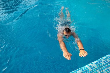 Genç bir atlet havuzun kenarına yüzer. Havuzda spor müsabakaları. Sağlıklı yaşam tarzı kavramı.
