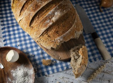 Tahta bir masada taze kırılmış ekmek.