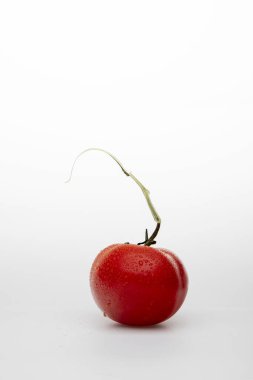 Beyaz zemin üzerinde su damlaları olan kırmızı domates