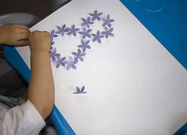 Ребенок делает открытку с картинкой 8 марта. Документы на ребенка. Материал для творчества. Детский сад — стоковое фото