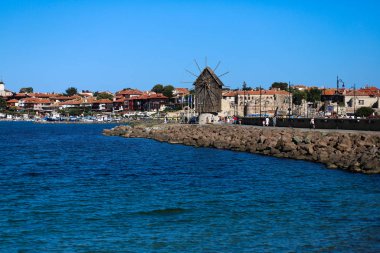 Nessebar, Bulgaristan, 08 Ağustos 2019 - Nessebar Eski Kenti'nin girişinde eski yel değirmeni, Bulgaristan'ın Karadeniz kıyısındaki antik kent. Uzaktan görüntüle