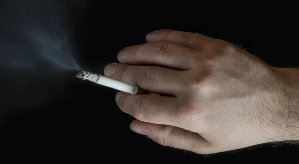 Bir sigara içen bir elinde smoldering