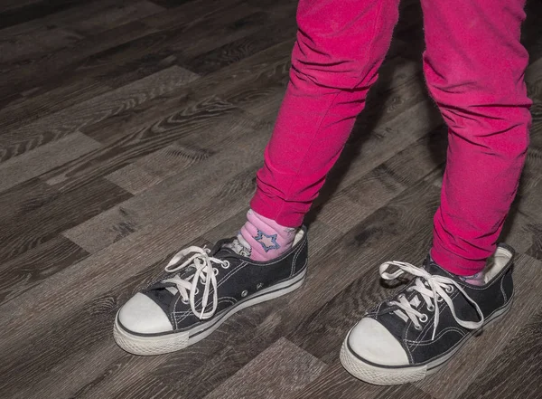 Das Mädchen trägt ein paar größere Schuhe — Stockfoto