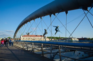 Krakow, Polonya - 12 Mayıs 2018: Köprü Krakow Kadka öfke Bernatka ya da Peder Bernatek yaya köprüsü Vistula Nehri, Krakow, Polonya. En sanatsal ve garip asma köprü, Krakow. Polonyalı ressam Jerzy Jotki K tarafından akrobatik figürler