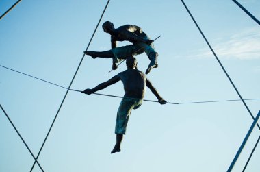 Krakow, Polonya - 12 Mayıs 2018: Köprü Krakow Kadka öfke Bernatka ya da Peder Bernatek yaya köprüsü Vistula Nehri, Krakow, Polonya. En sanatsal ve garip asma köprü, Krakow. Polonyalı ressam Jerzy Jotki K tarafından akrobatik figürler