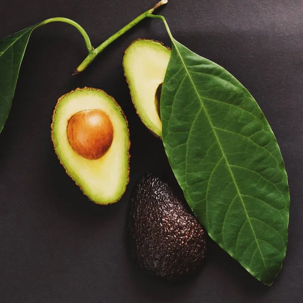 Rijp Fris Zwart Avocado Met Blad Donkere Achtergrond Bovenaanzicht — Stockfoto