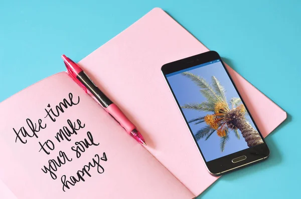 Teks tentang perjalanan di notebook merah muda, foto di smartphone di latar belakang biru, berbaring datar. Konsep blogging, smm. Liburan musim panas — Stok Foto