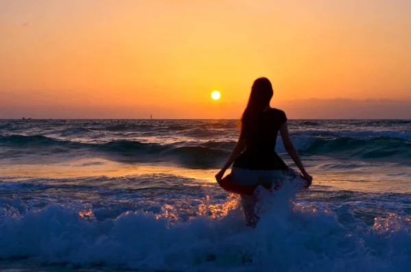 Жінка стоїть на морському узбережжі і дивиться на горизонт — стокове фото
