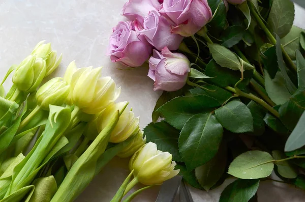 Beautiful flowers tulips and roses on marble background