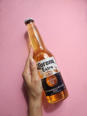 Kiev, Ukrayna - 6 Mart 2019: Corona ilave bira şişe pembe bir arka plan üzerinde. Açıklayıcı editoryal fotoğraf