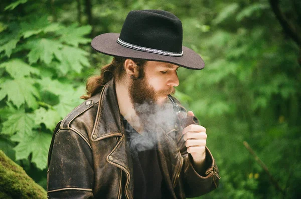 Foto de película. Retrato del hombre barbudo en sombrero fumando pipa de tabaco . — Foto de Stock
