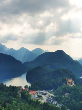 Fussen yakınlarındaki Bavyera Alpleri'nde puslu bir gün, Almanya. Almanya'da bir yaz gününde Alpler ve göller. Neuschwanstein Kalesi'nin yanındaki tepeden alınmış. Hohenschwangau kalesinin görünümü, Bavyera Alpleri, Schwansee, Alpsee. Bavyera. 
