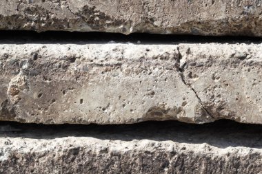 Bir biri üst üste yığılmış bir çatlak ile gri beton levhalar lineer doku yakın çekim yan görünüm. Kavramsal veya metafor duvar afişi, grunge, malzeme, yaşlı, inşaat.