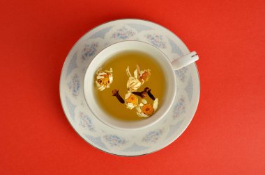 Kırmızı zemin üzerine bitkisel çay