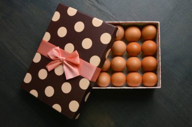 Bir yarı içinde çiğ yumurta hediye kutusu siyah arka plan üzerine açık