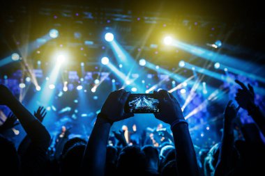 Akıllı telefondan konserin video kaydı. Gösterinin mavi kavramsal arkaplanı.