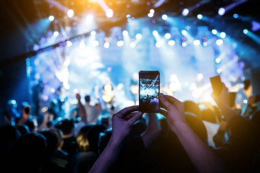 El kameralı akıllı telefon bir konseri filme çekiyor.