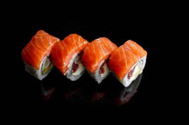 Somonlu dört klasik suşi. Üst görünüm, siyah arkaplan
